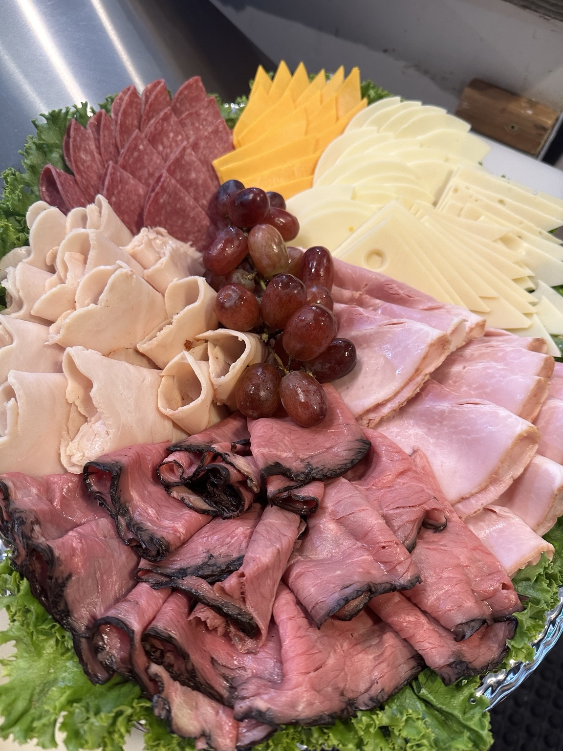 Uptown Bagel Co. catering platter with meats, cheeses, and grapes